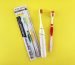 Flat lay of manual and electric toothbrushes with vibrant yellow background.